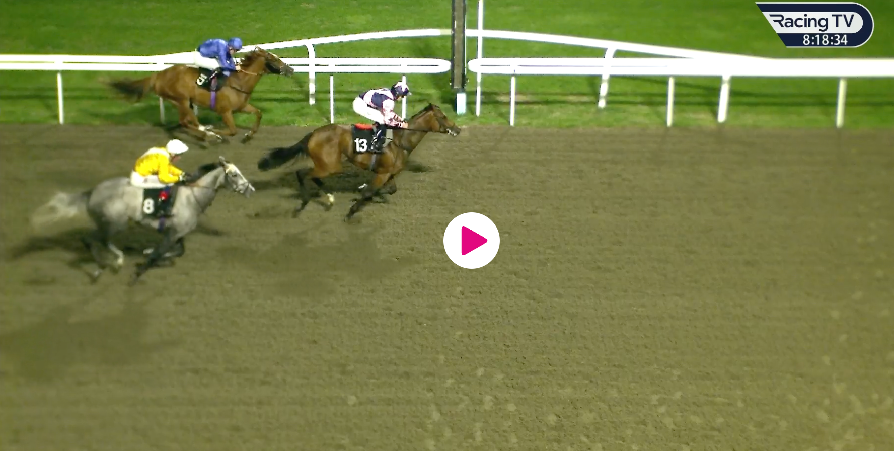 Horses racing on a dirt track at night. Three horses are neck and neck nearing the finish line.