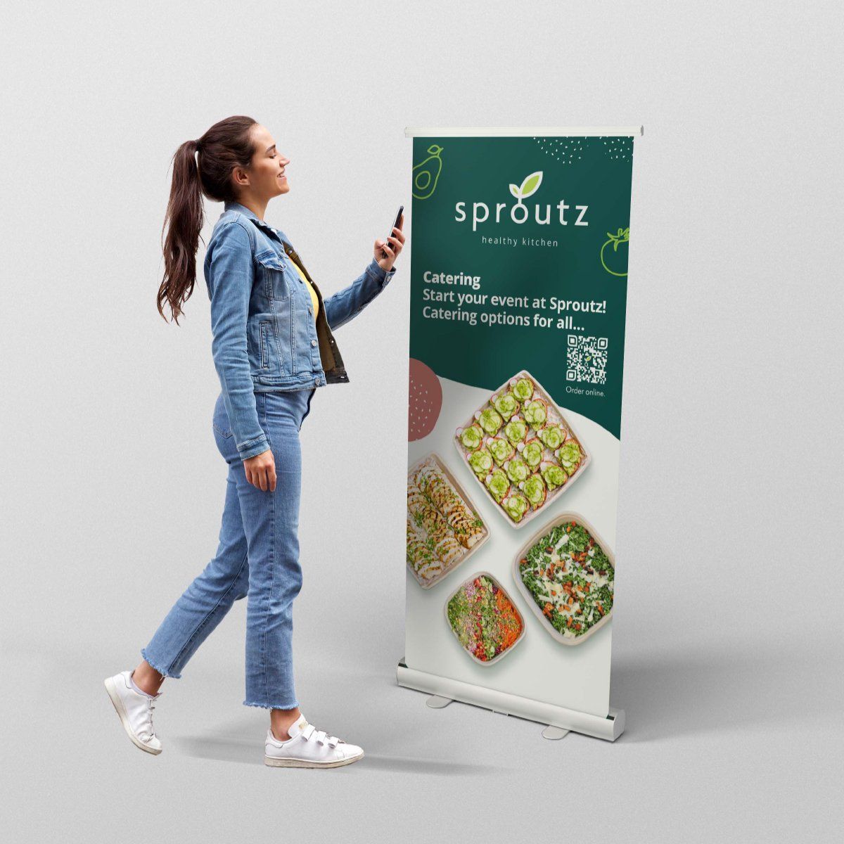 A woman is standing in front of a sproutz banner
