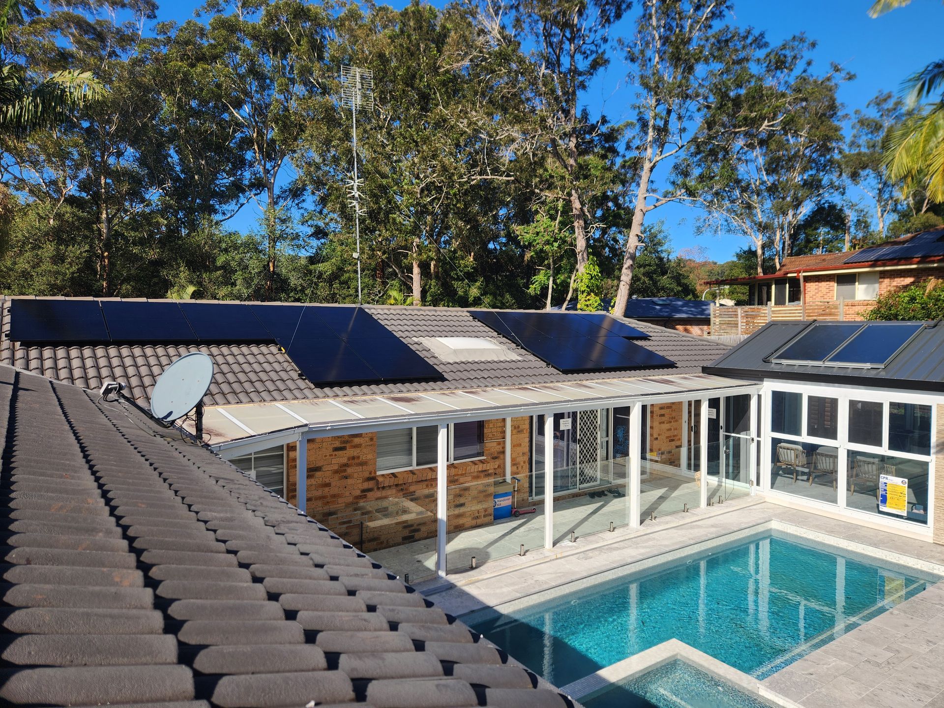 A House With a Swimming Pool and Solar Panels on the Roof — Solar Services in Terrigal, NSW