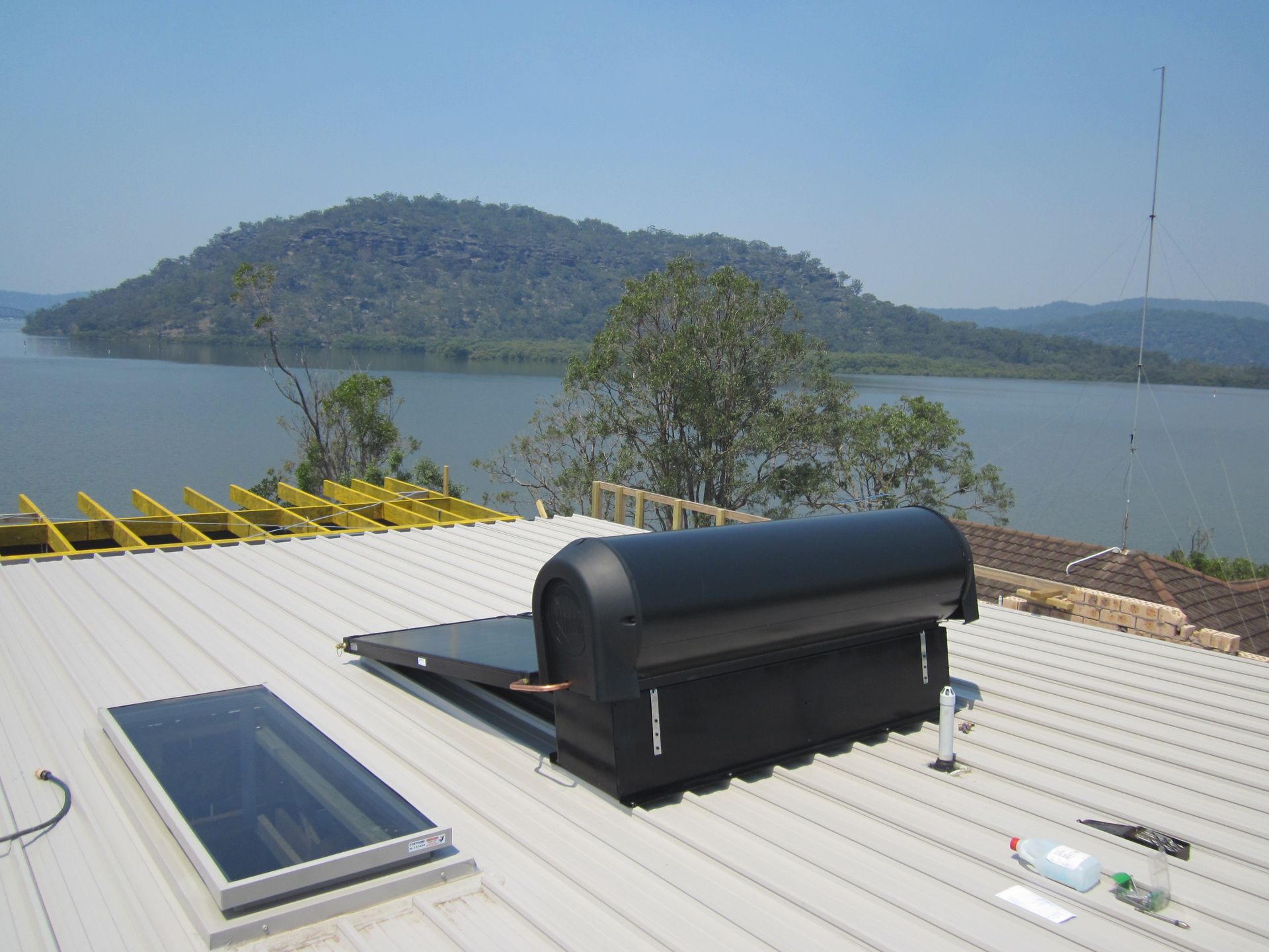Solar Panels on A Residential Roof with a river in the background — Solar Services in Erina, NSW