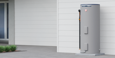 Gray Water Heater Against a White Wall and a Light Gray Concrete Slab — Solar Services in Erina, NSW