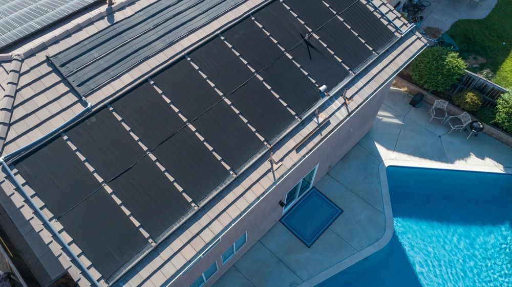 Aerial View Of A Building Roof Beside A Blue Swimming Pool — Solar Services in Erina, NSW