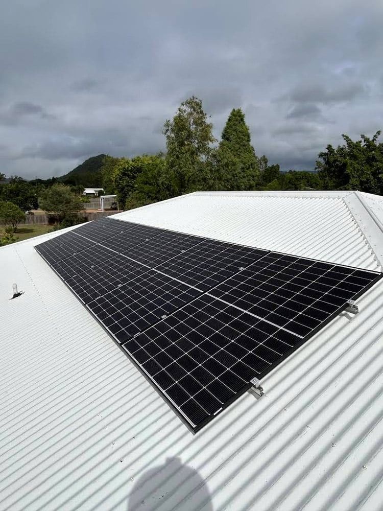 A white roof with black solar panels on it — Solar Services in Erina, NSW