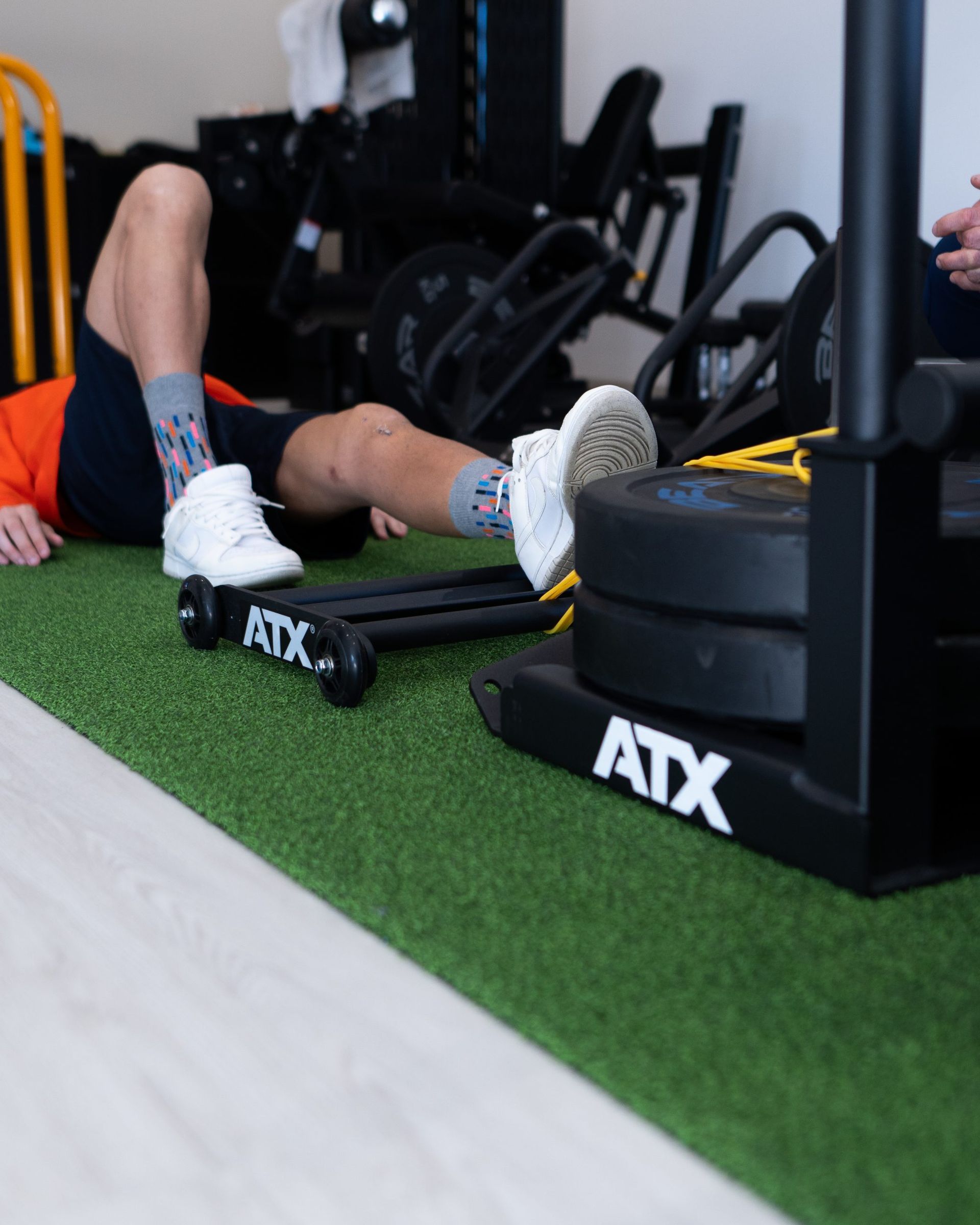 Una persona è sdraiata sul pavimento di una palestra.