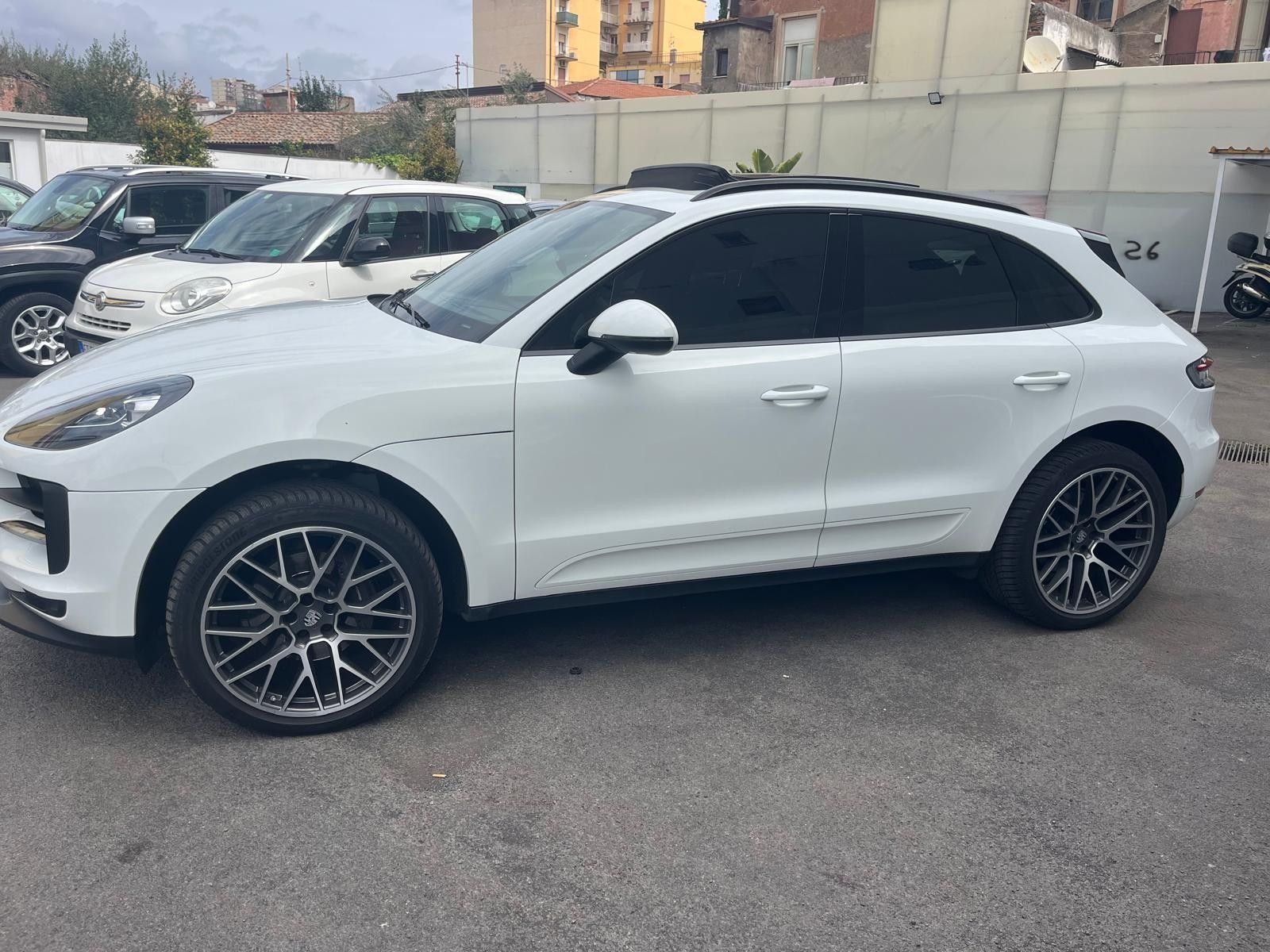 SUV Porsche bianco parcheggiato all'aperto. Cerchi neri, vetri oscurati.