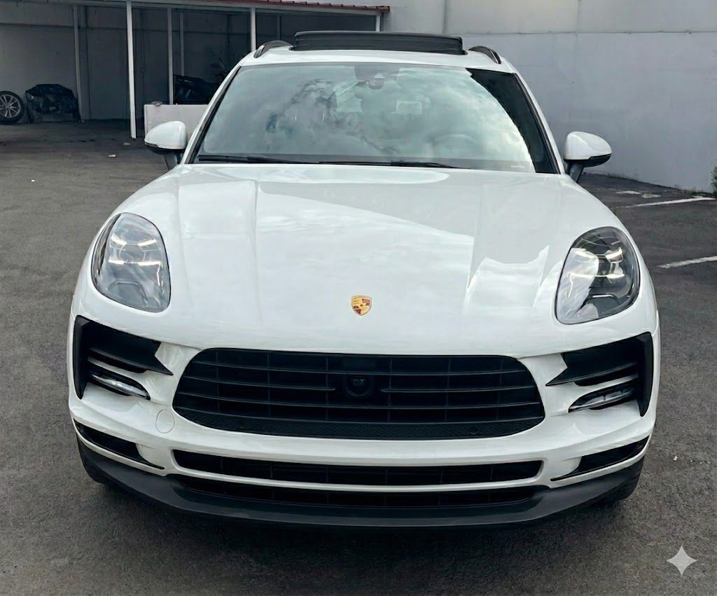 SUV Porsche Macan bianco con dettagli neri, vista frontale.