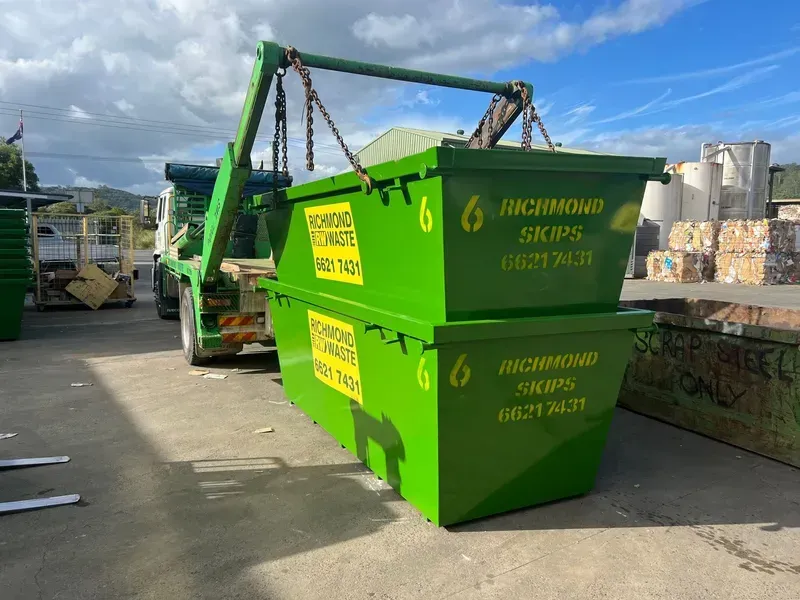 Two Stacked Green Richmond Skips Bins Being Lifted by a Truck — Hasti Skips in Bangalow, NSW