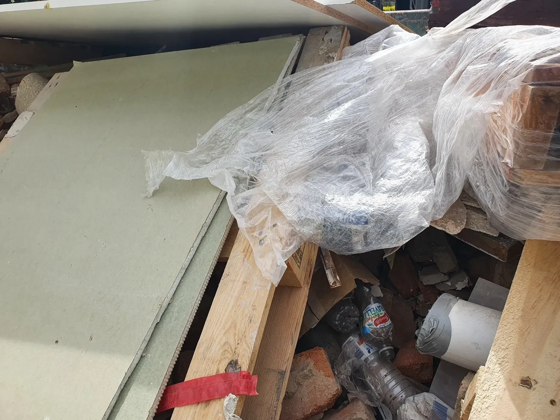 Pile of Construction Debris: Drywall, Wood, Plastic Wrap, Bricks, and Bottles — Hasti Skips in Kingscliff, NSW