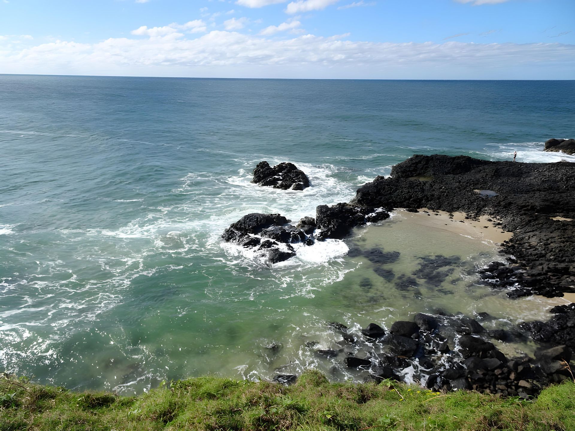 Ocean View With Rocky Coast, Turquoise Water, and Blue Sky With Clouds — Hasti Skips in Ocean Shores, NSW