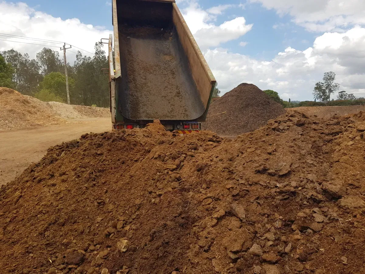Truck Bed Dumping Soil Onto a Large Pile. Brown Earth on a Dirt Lot Under a Blue Sky — Hasti Skips in Ocean Shores, NSW