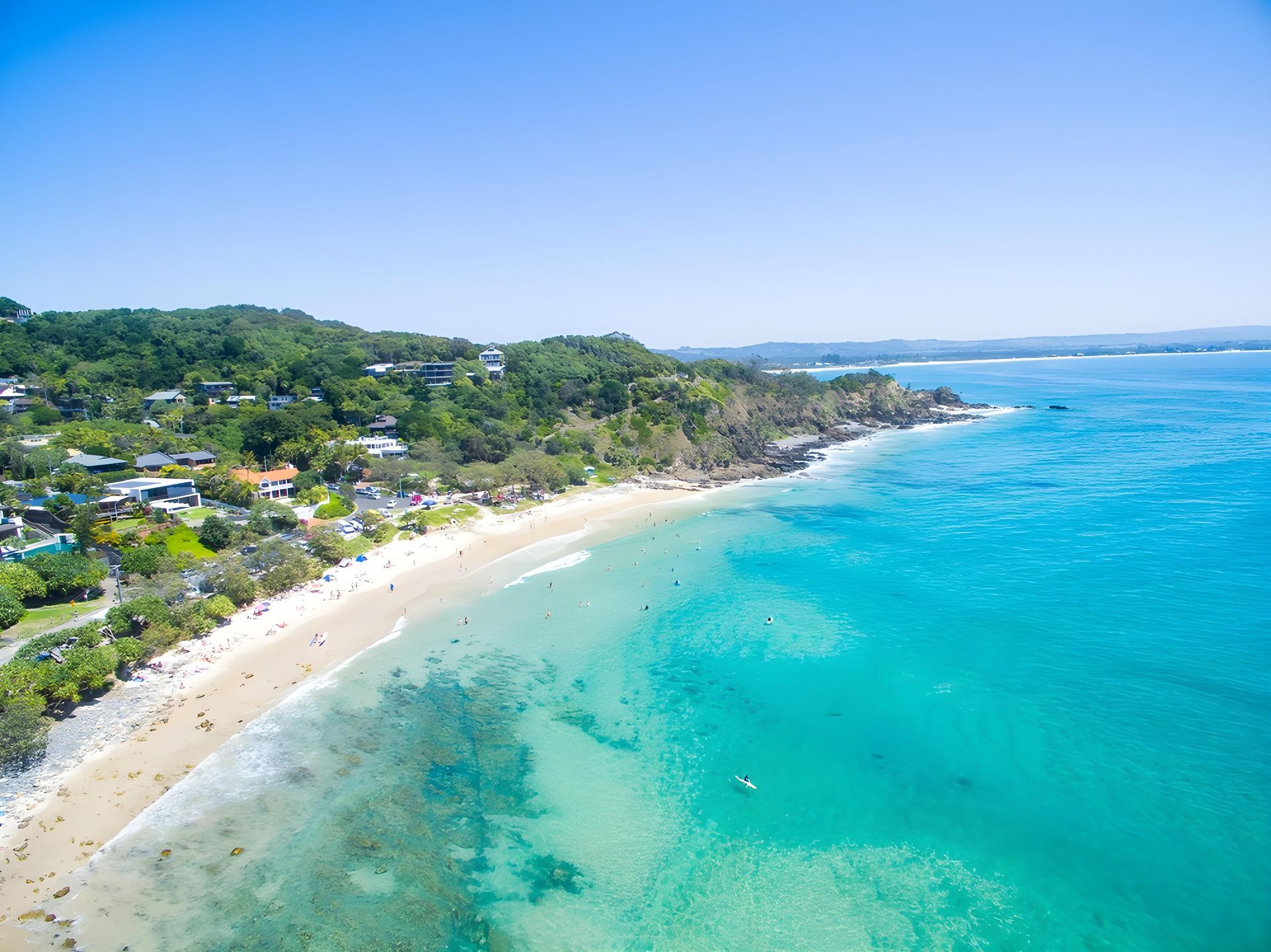 Aerial View of a Sunny Beach With Turquoise Water, White Sand, and Green Trees — Hasti Skips in Byron Bay, NSW