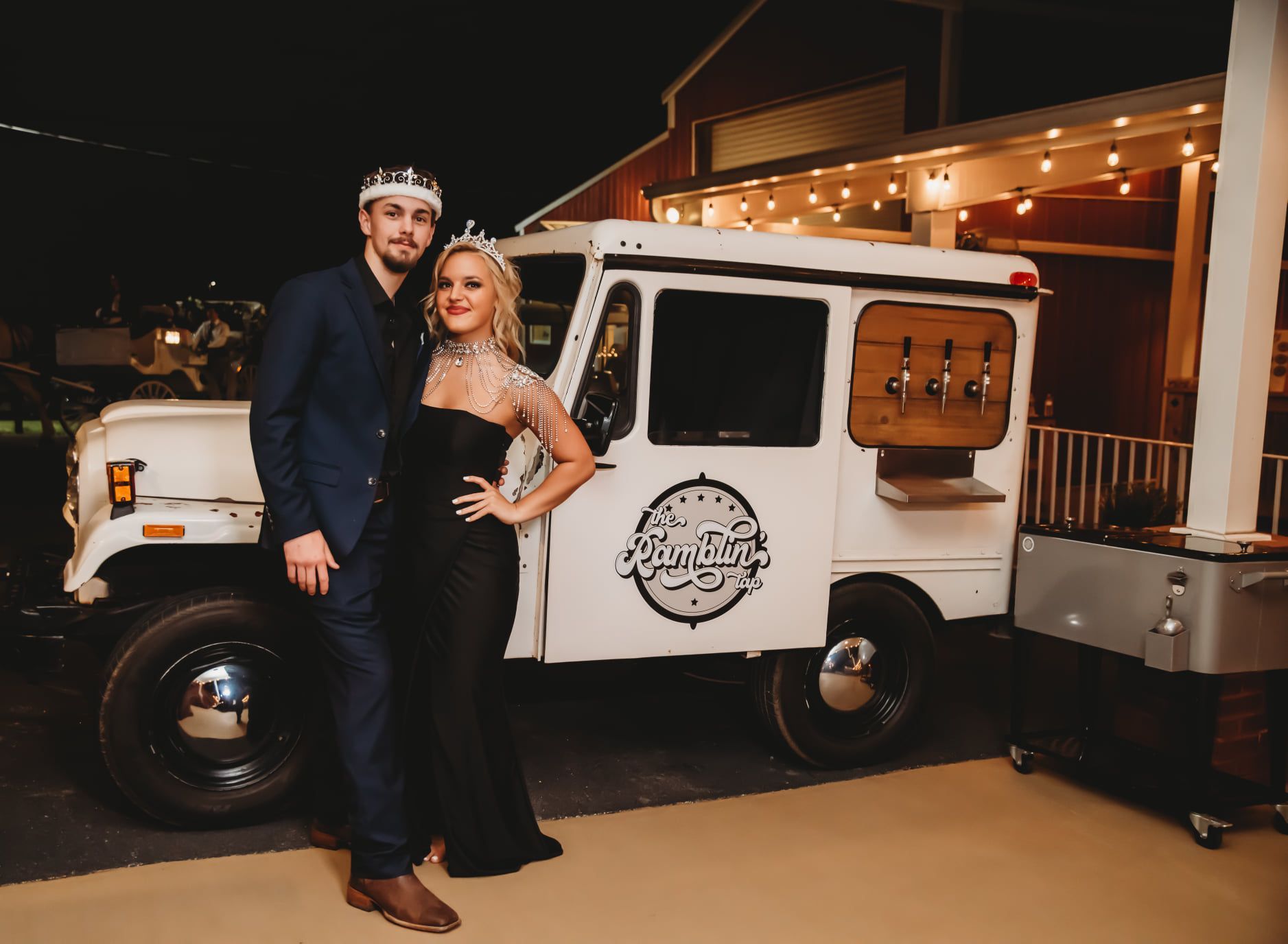 A man and a woman are standing in front of a white truck.