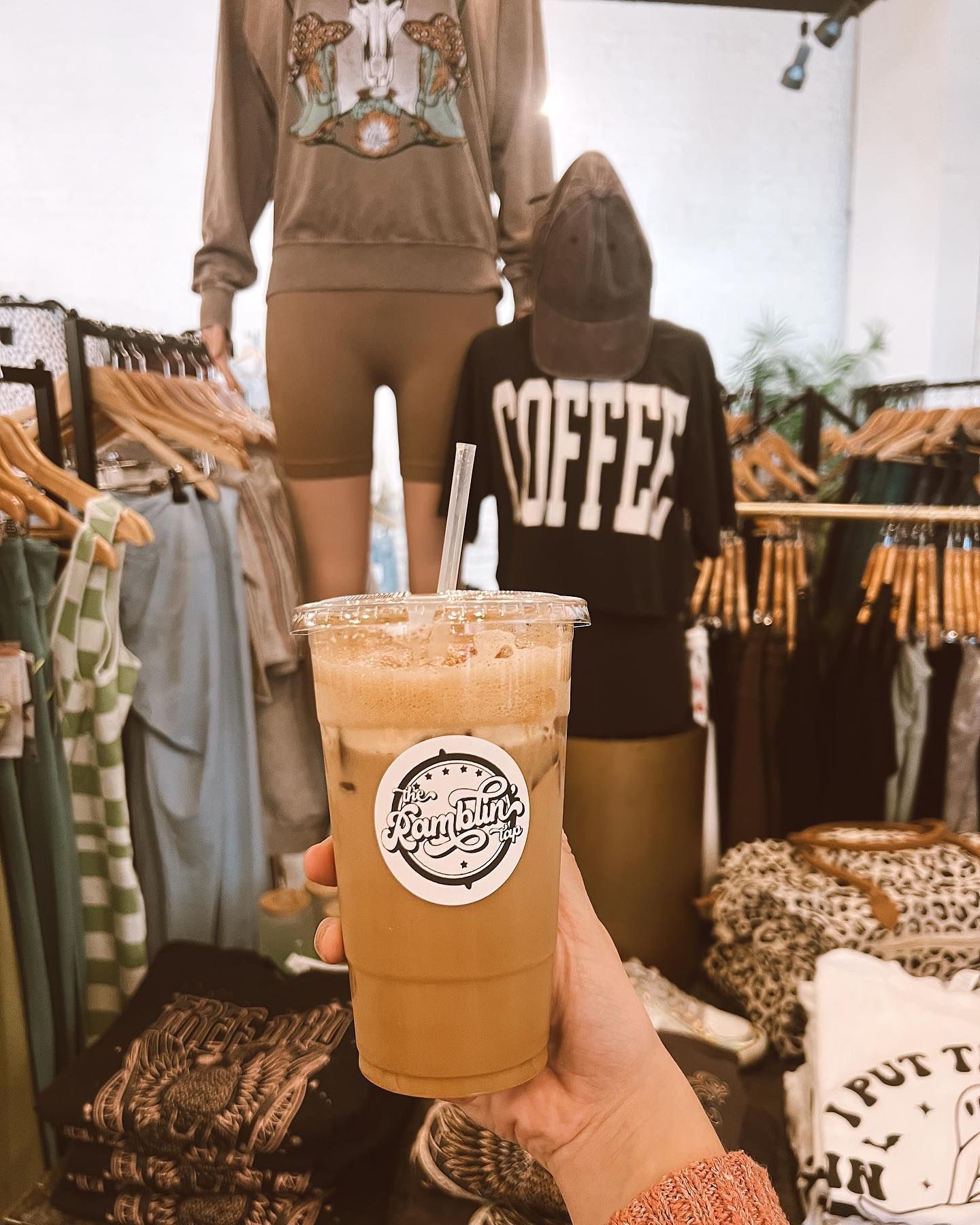 A person is holding a cup of coffee in a store.