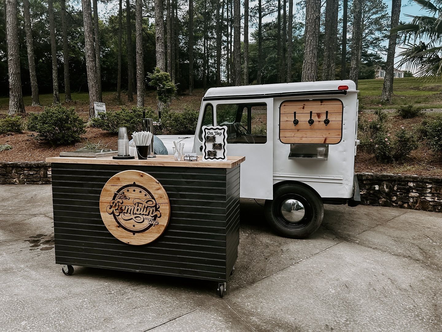 A white truck with a wooden bar on the back is parked in a parking lot.