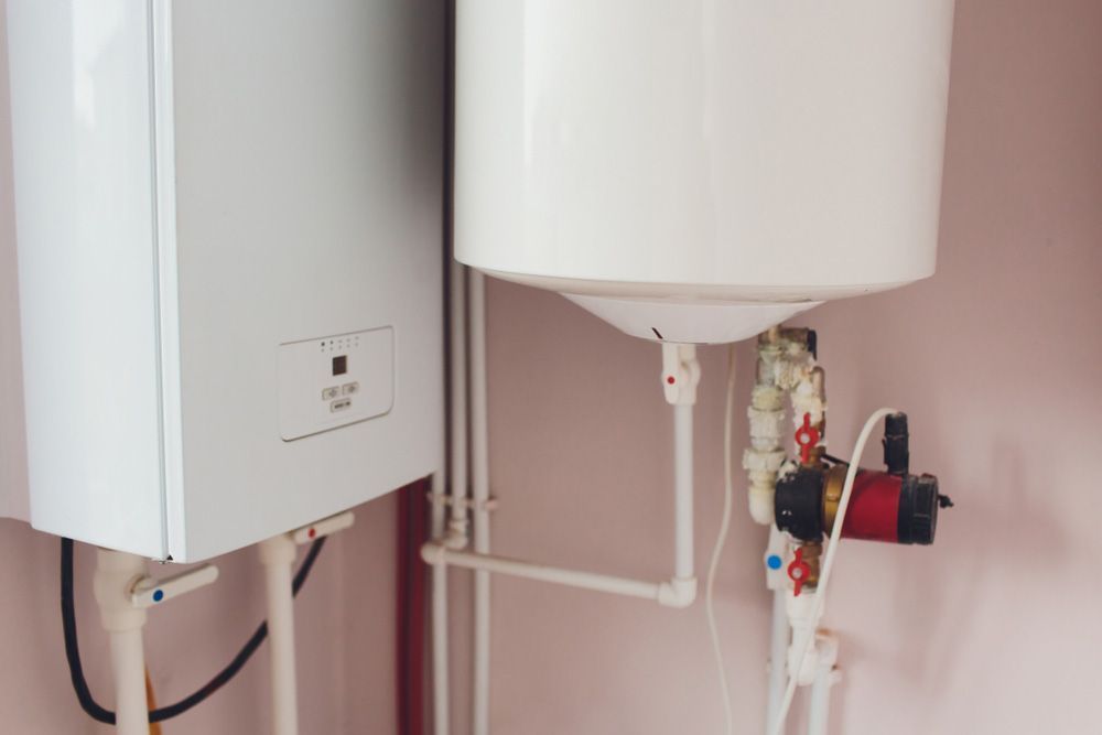 Two Water Heaters Are Sitting Next to Each Other in a Room — Foreshore Plumbers In Tuncurry, NSW