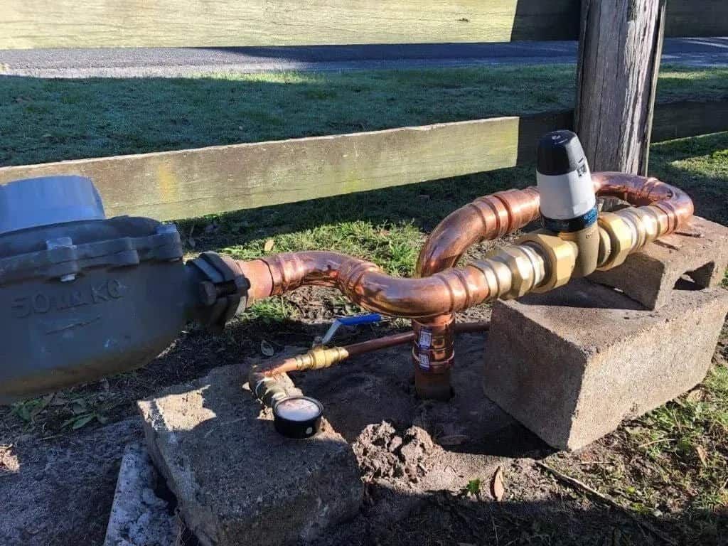 A Close Up of a Water Meter With Copper Pipes Attached to It — Foreshore Plumbers In Tuncurry, NSW