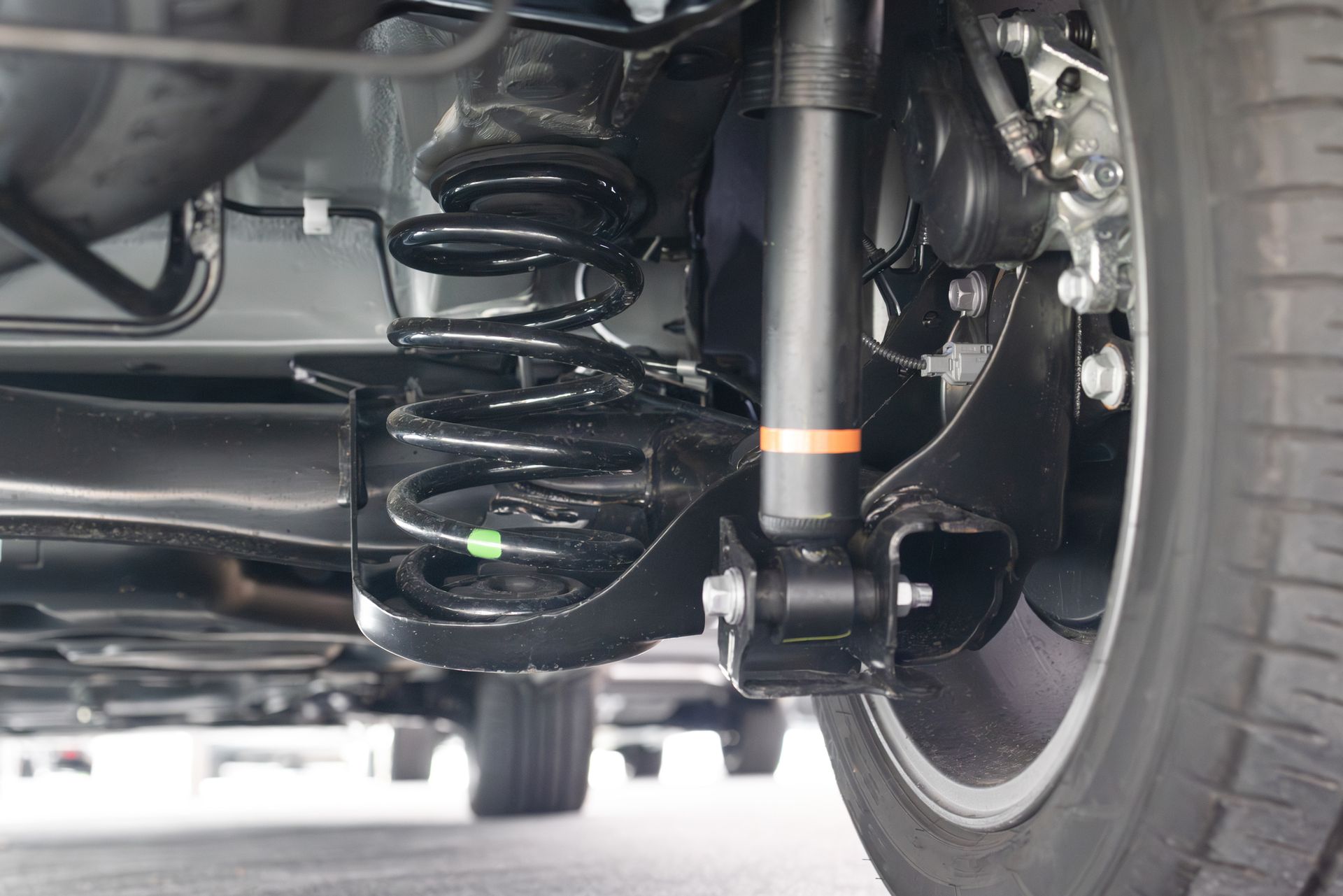 Close-up of modern 4x4 suspension upgrades installed on rear wheel assembly.