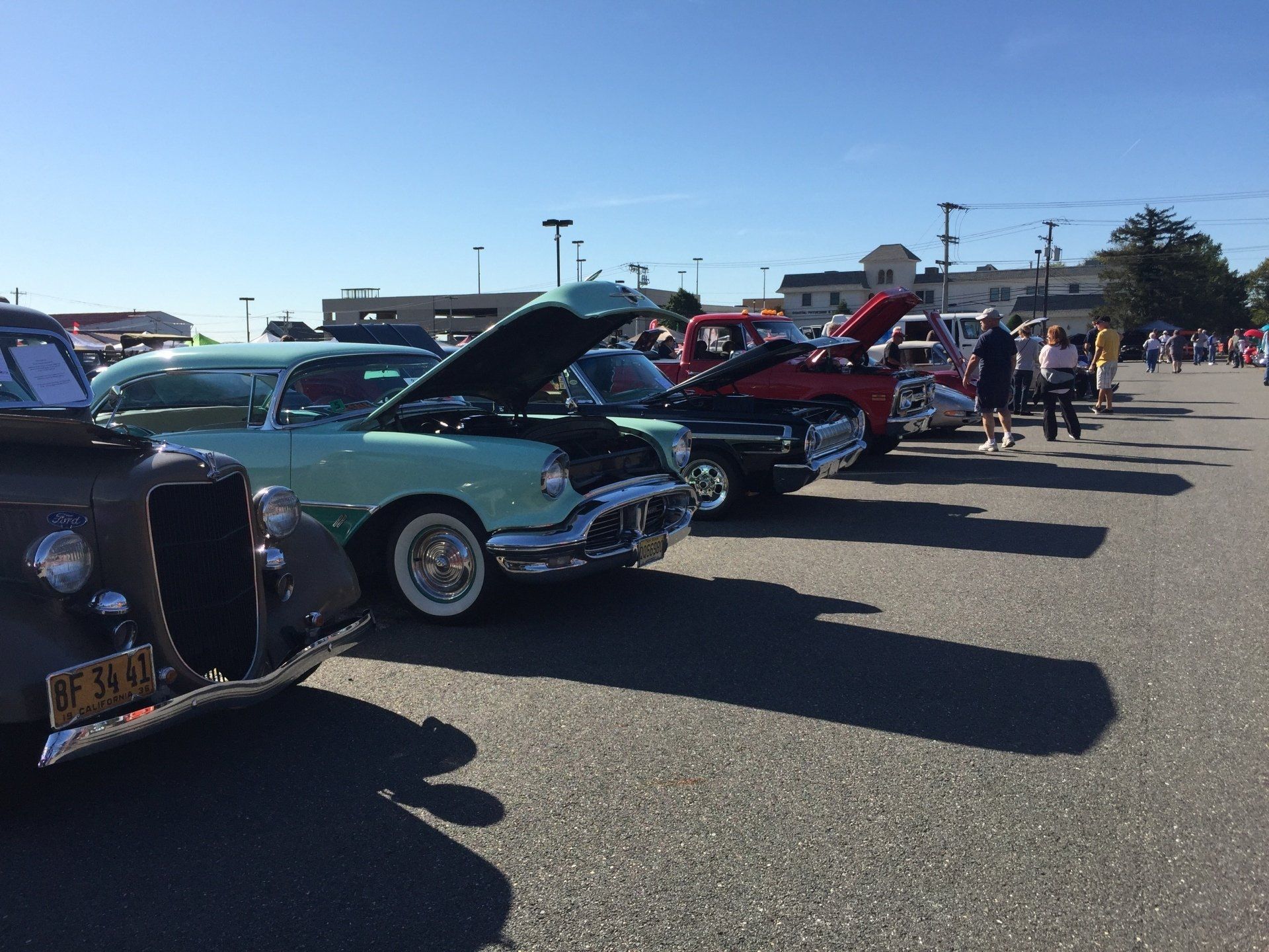 A row of old cars are parked in a parking lot