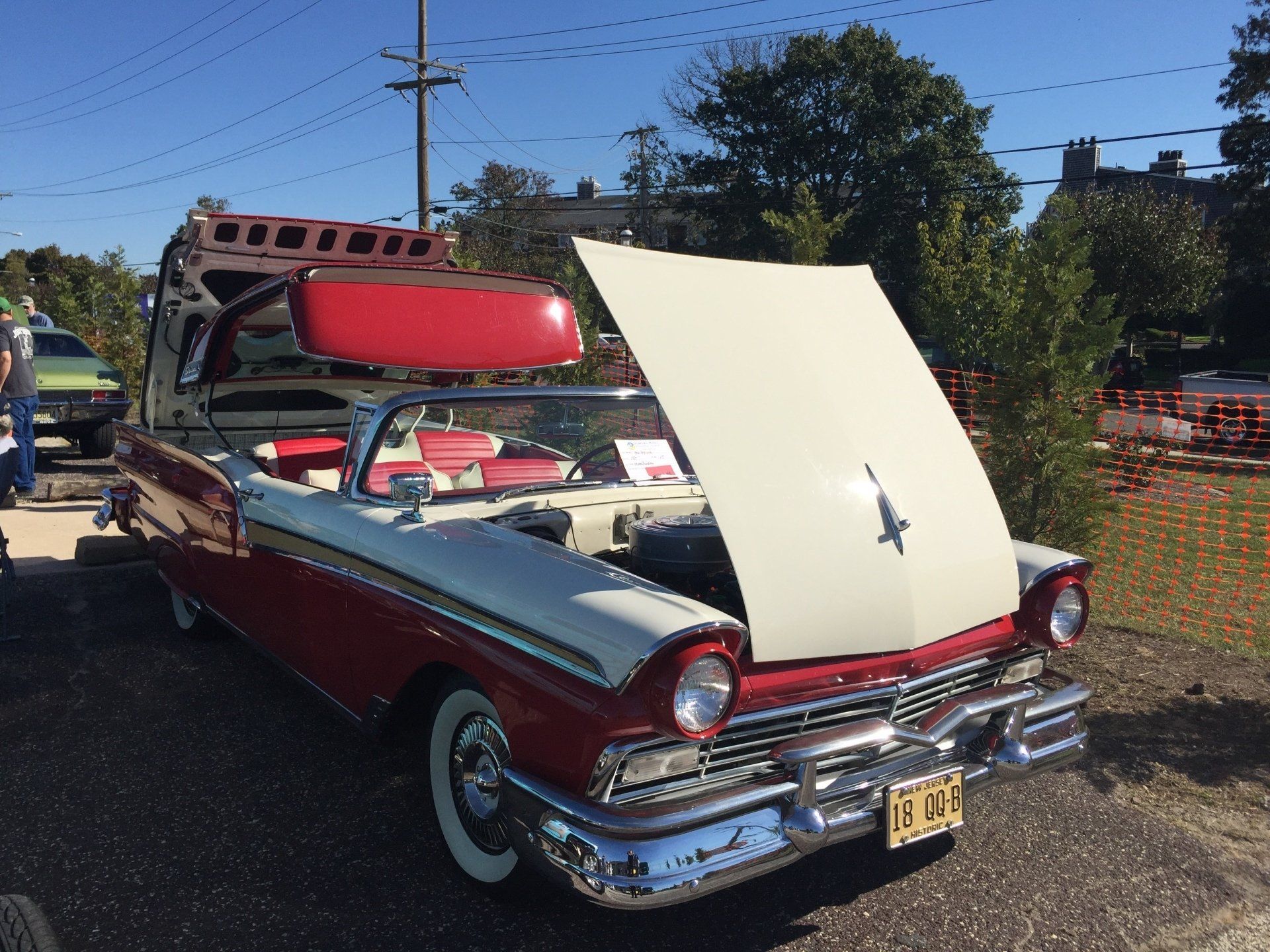 A red and white ford convertible with the hood up