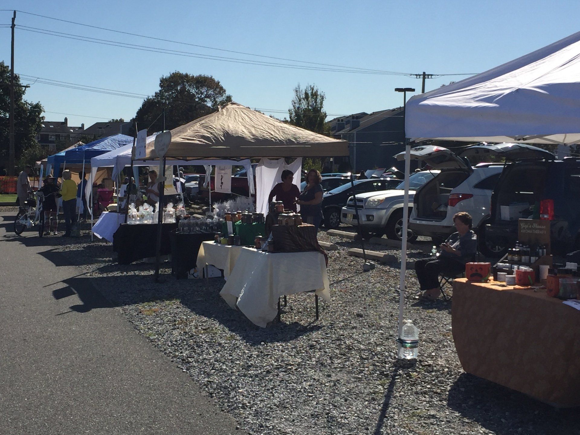 A parking lot filled with tables and tents on a sunny day