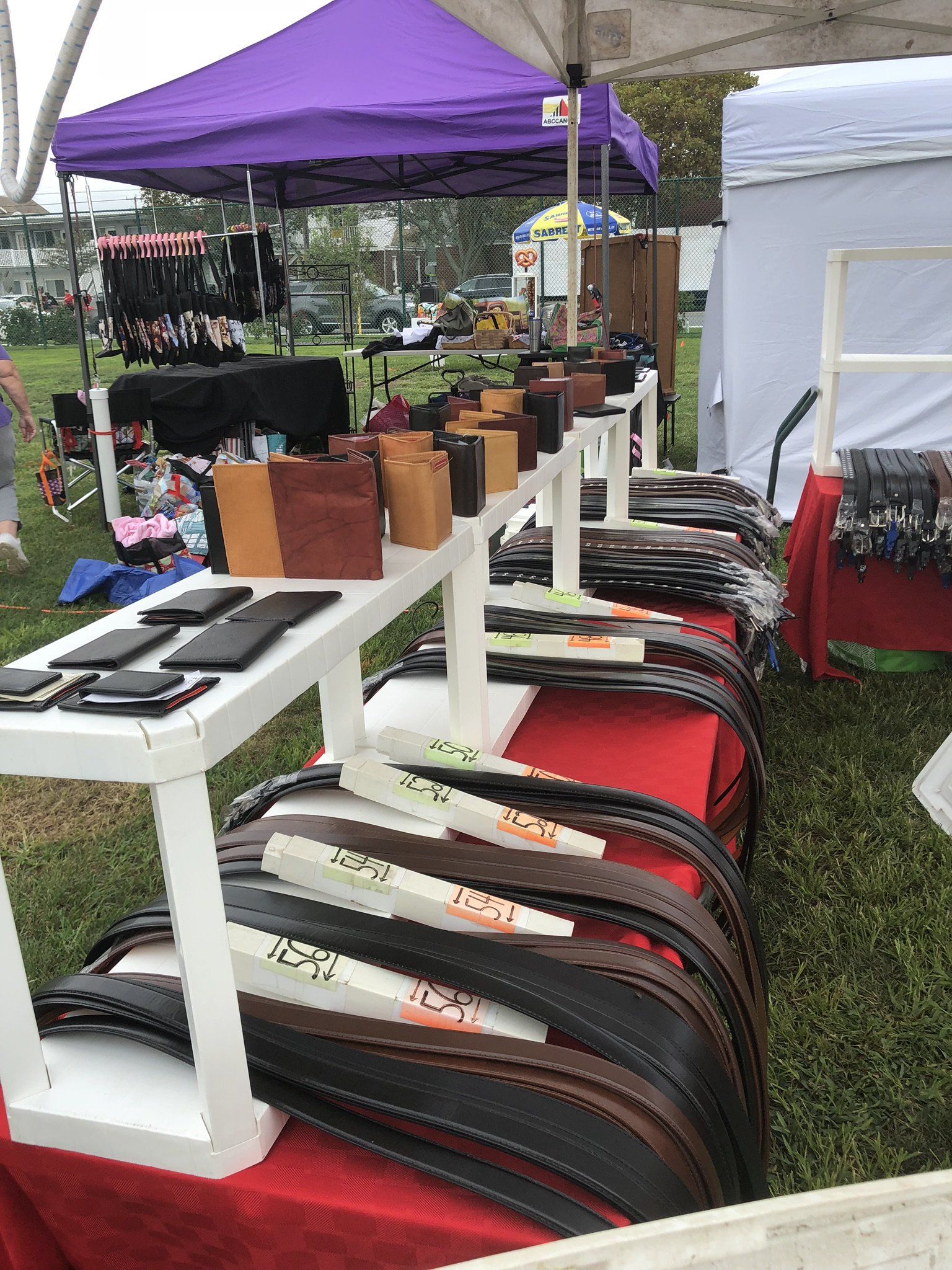 A bunch of belts are sitting on a table at a market.