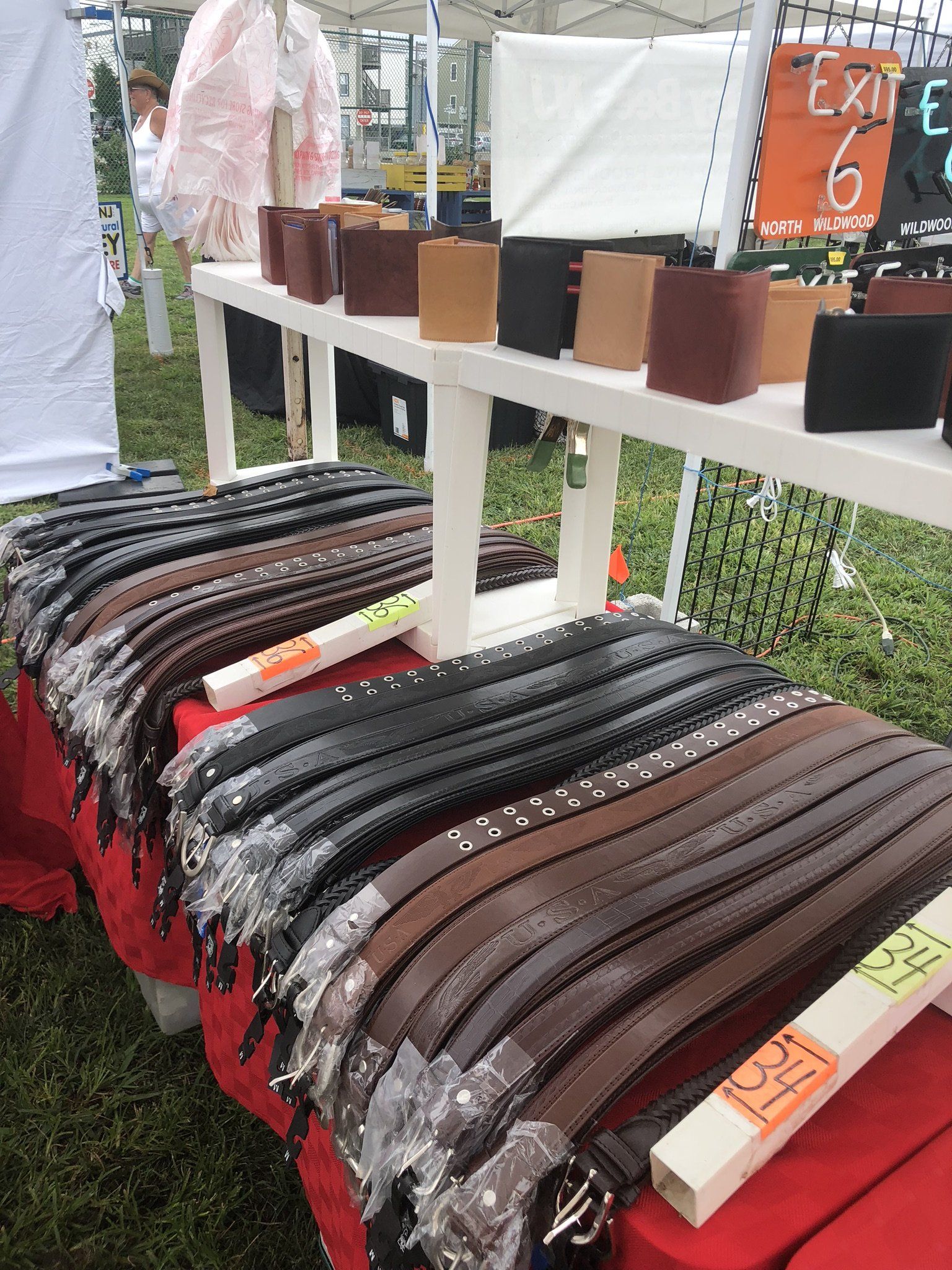 A table with a lot of belts and wallets on it