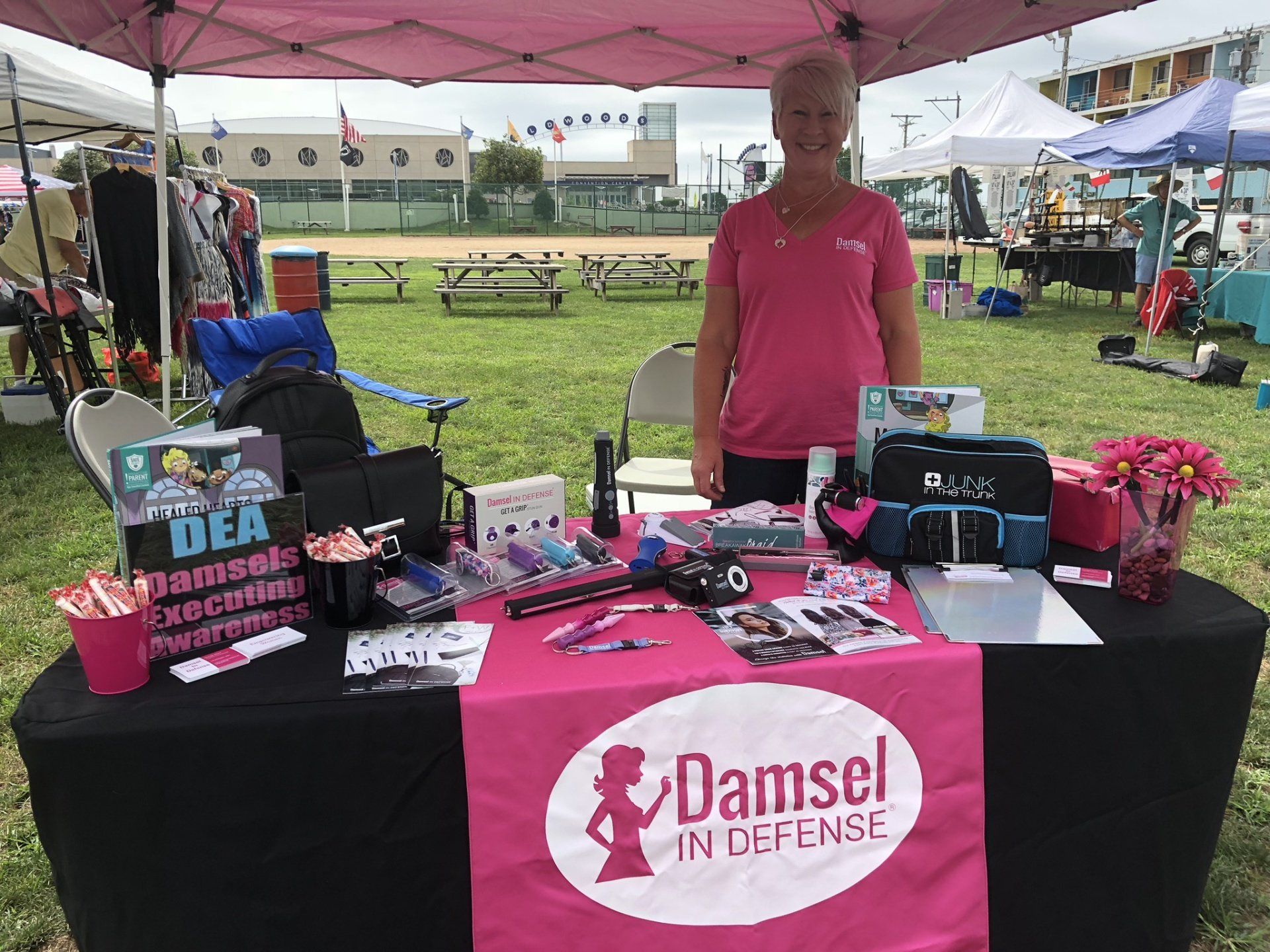 A woman is standing in front of a table with a pink table cloth.