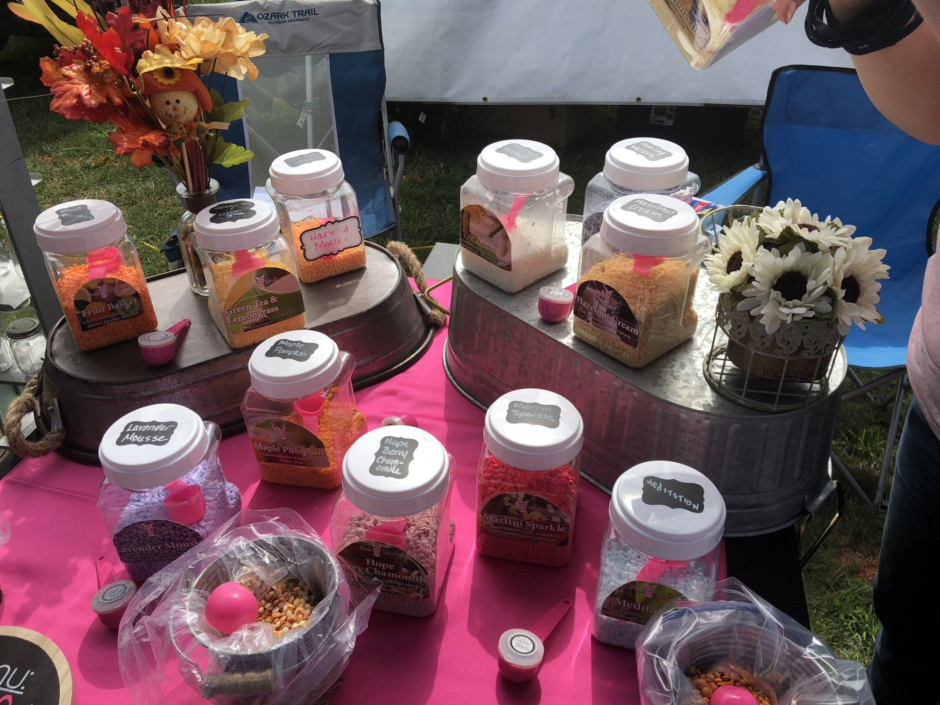 A table topped with jars of food and flowers.