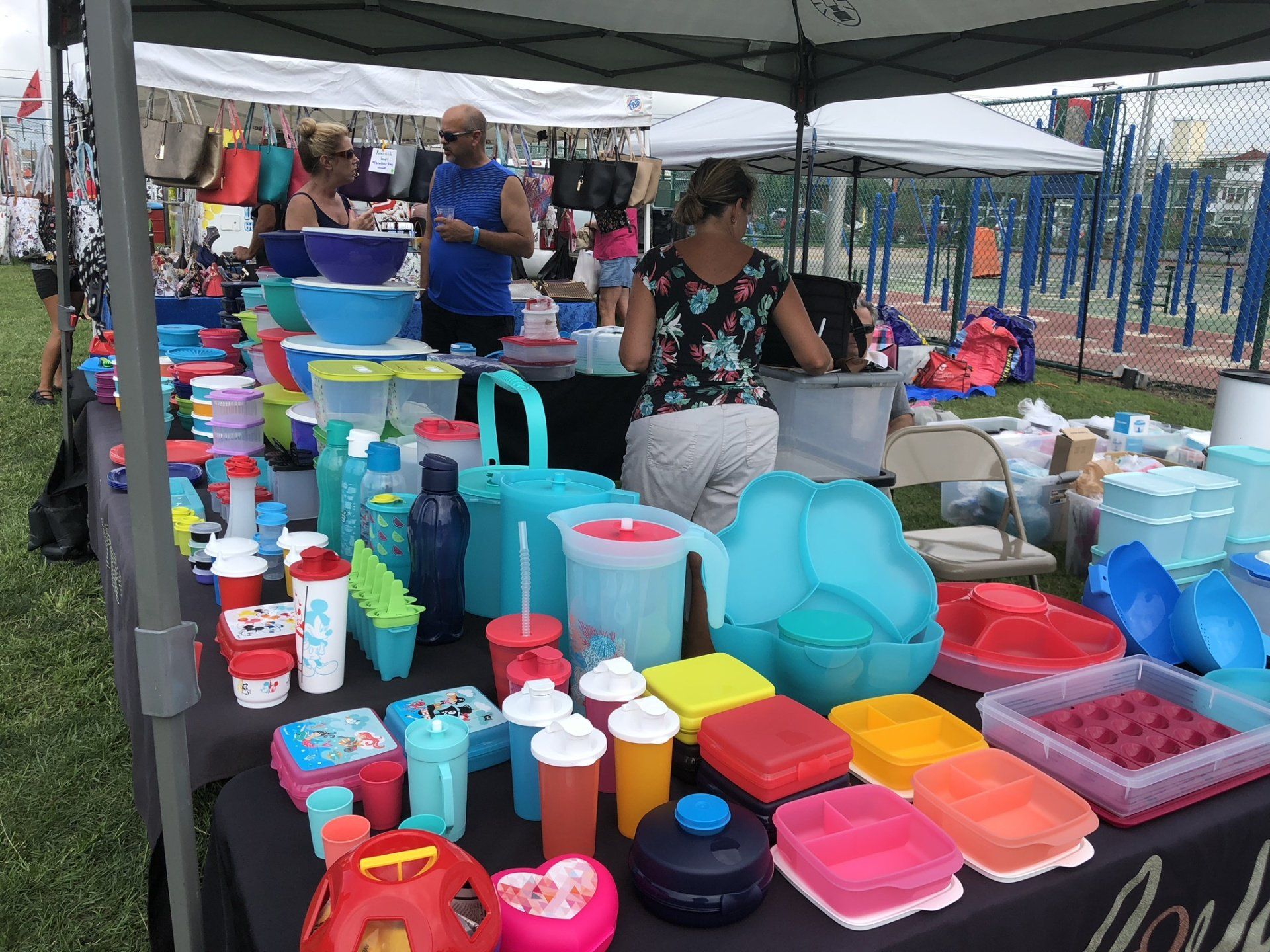 A table filled with lots of colorful plastic containers and bowls.