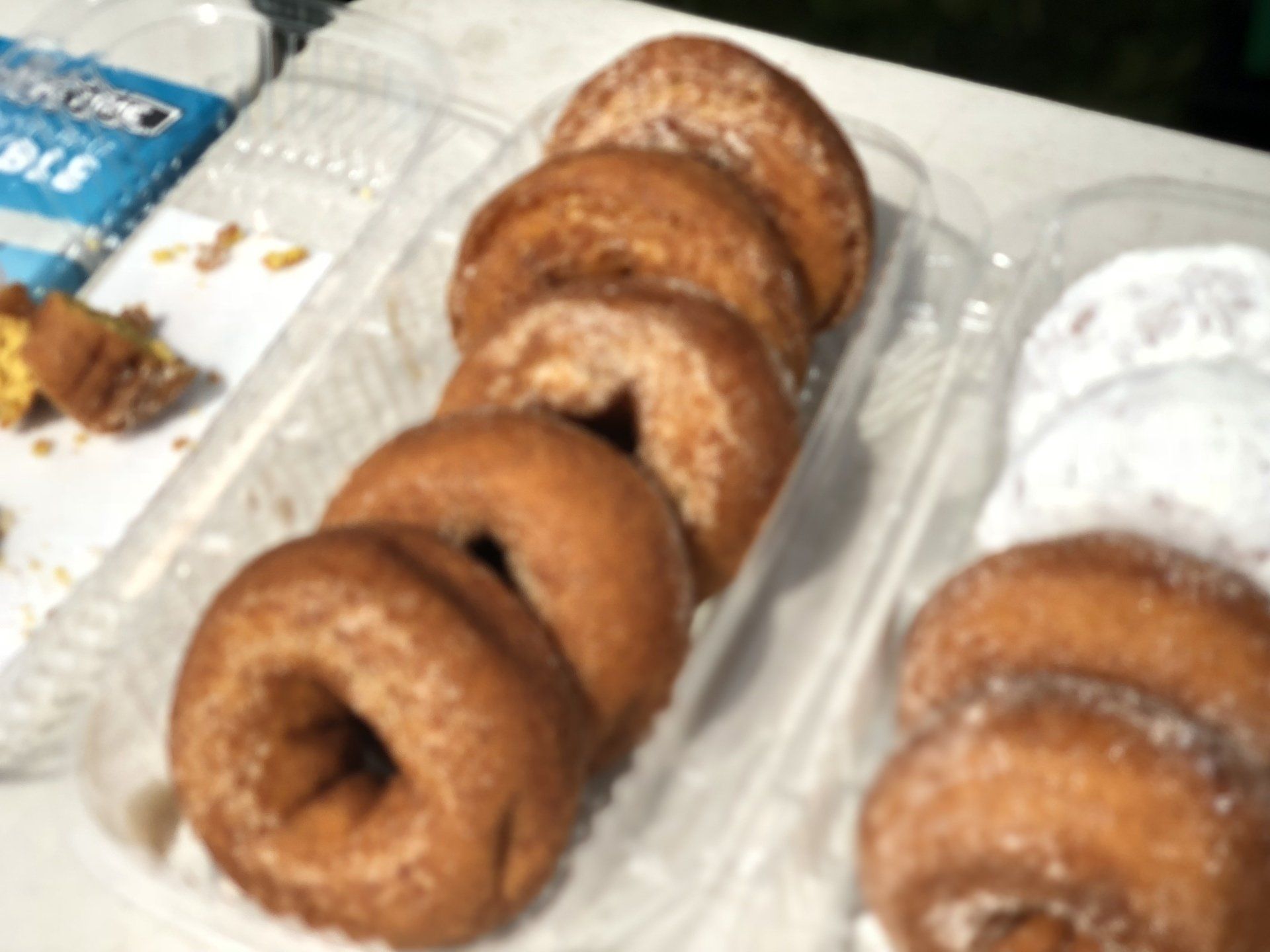 A bunch of donuts in plastic containers on a table