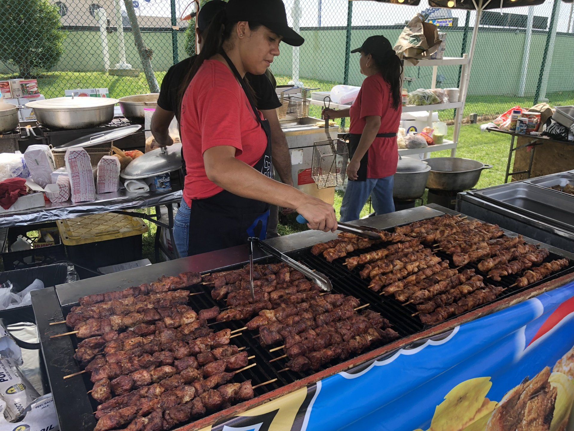 A group of people are cooking food on a grill.