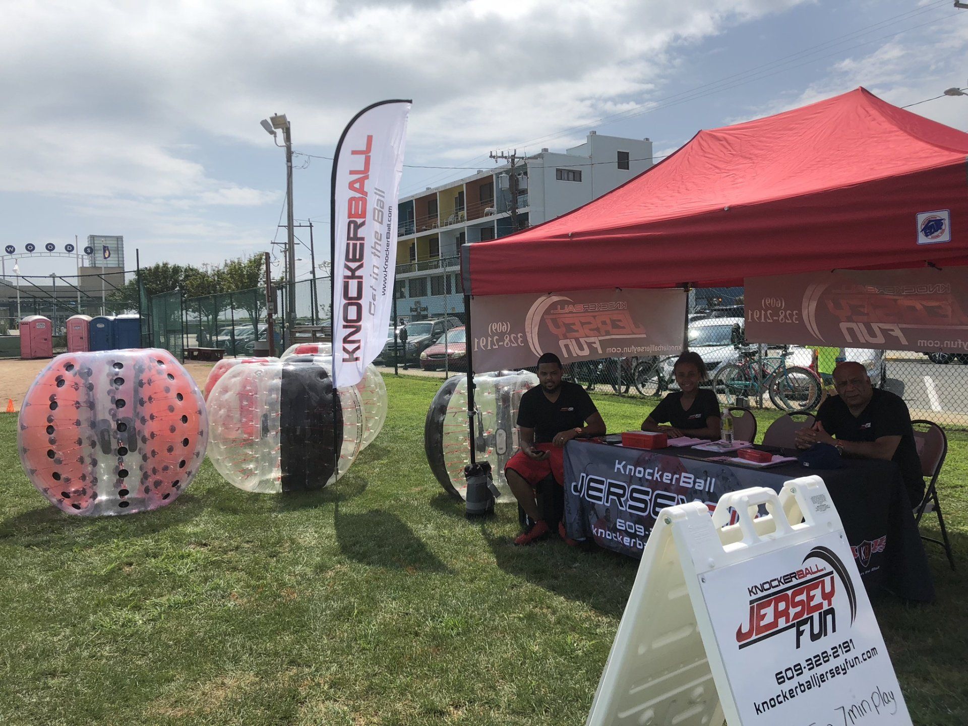 A group of men are sitting at a table under a tent in a park.