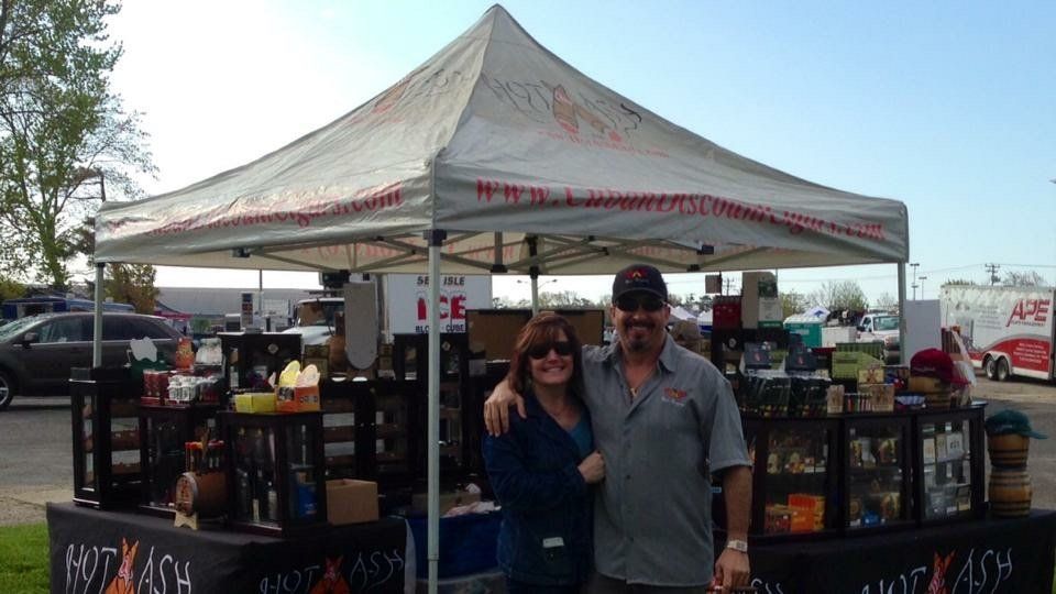 A man and a woman are posing for a picture under a tent