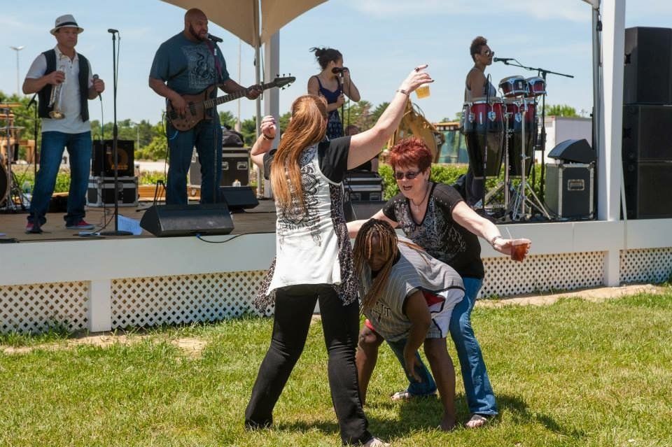 A group of people are dancing in front of a band on a stage.