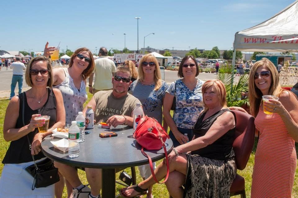 A group of people are sitting around a table holding drinks.