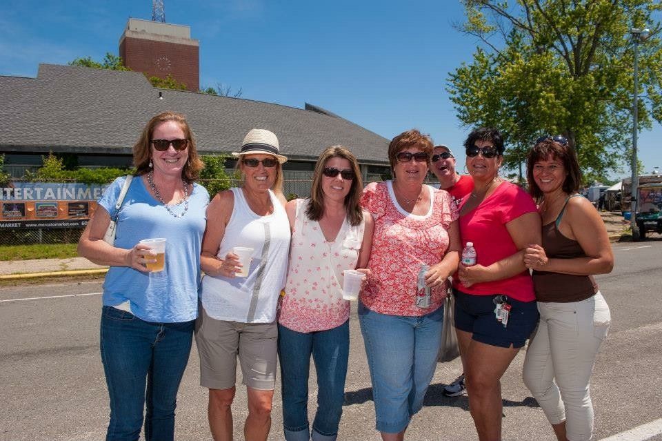 A group of women are posing for a picture in front of a building that says entertainment