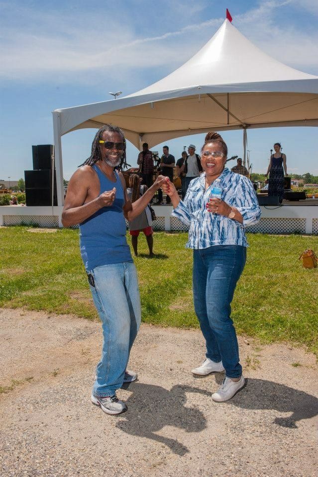 A man and a woman are dancing in front of a tent.