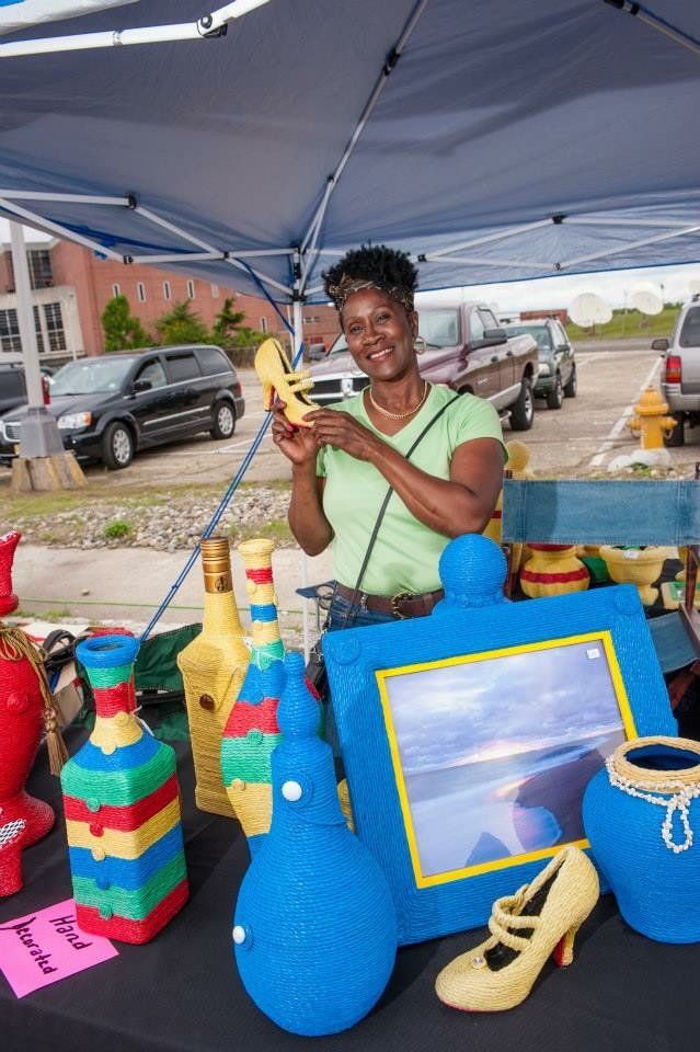 A woman is standing in front of a table holding a banana.