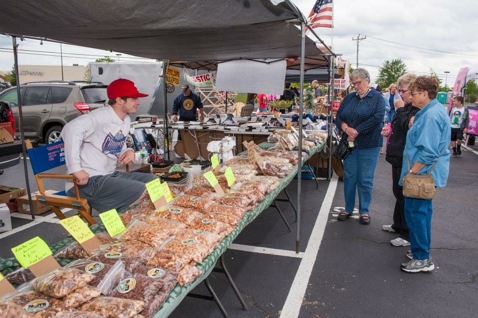 A man in a red hat is selling nuts at a market