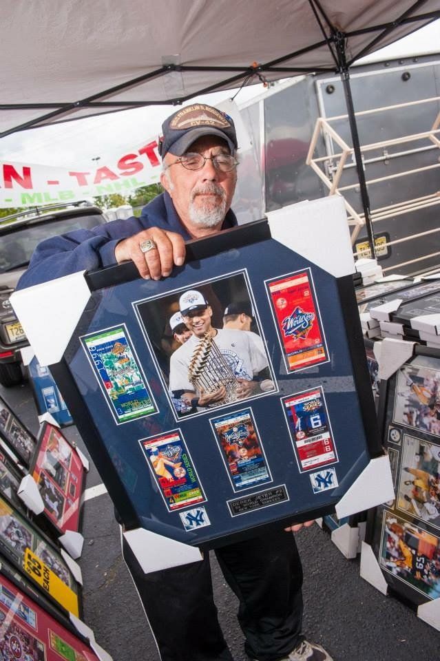 A man is holding a framed picture of a man