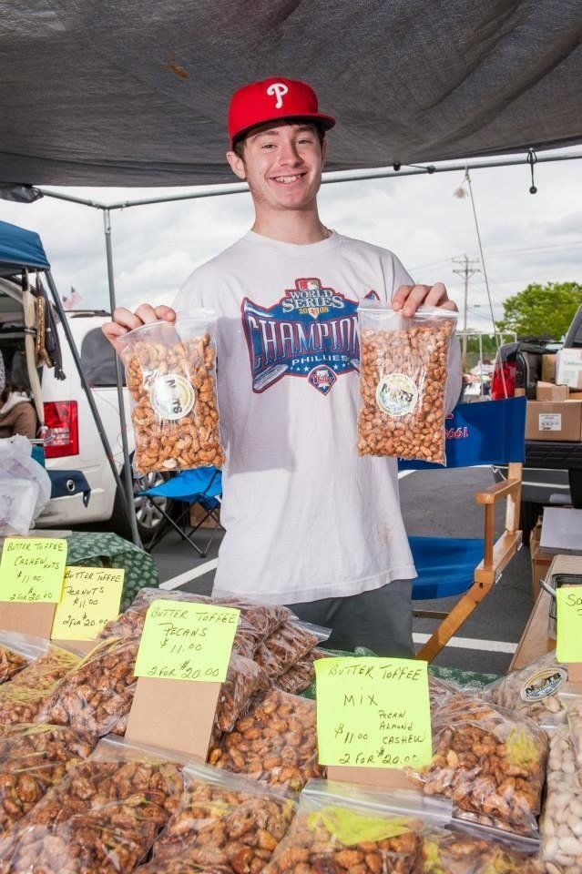 A man wearing a red hat is holding two bags of nuts.