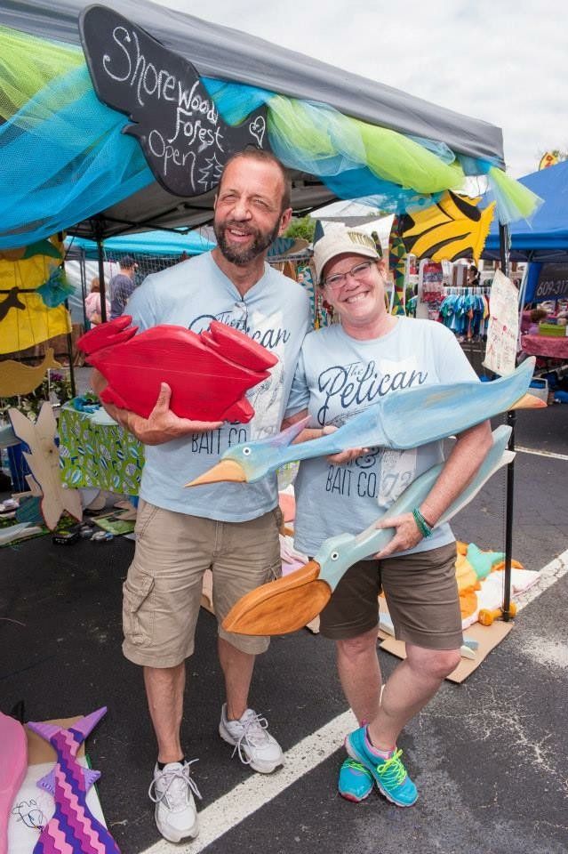 A man and a woman are standing next to each other holding toys.