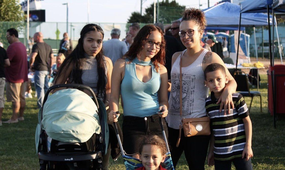 A group of people are posing for a picture in a park.