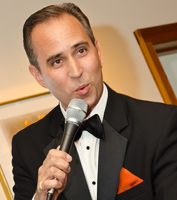 A man in a tuxedo is holding a microphone