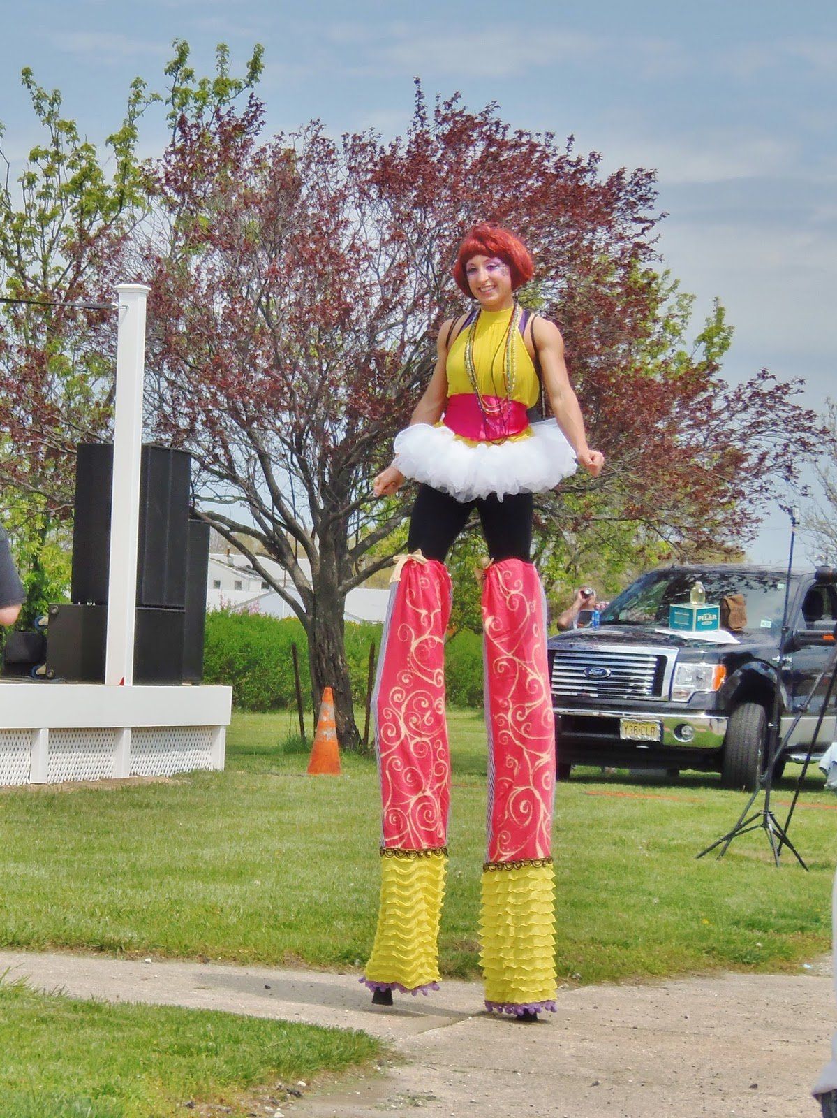 A woman is walking on stilts in a park