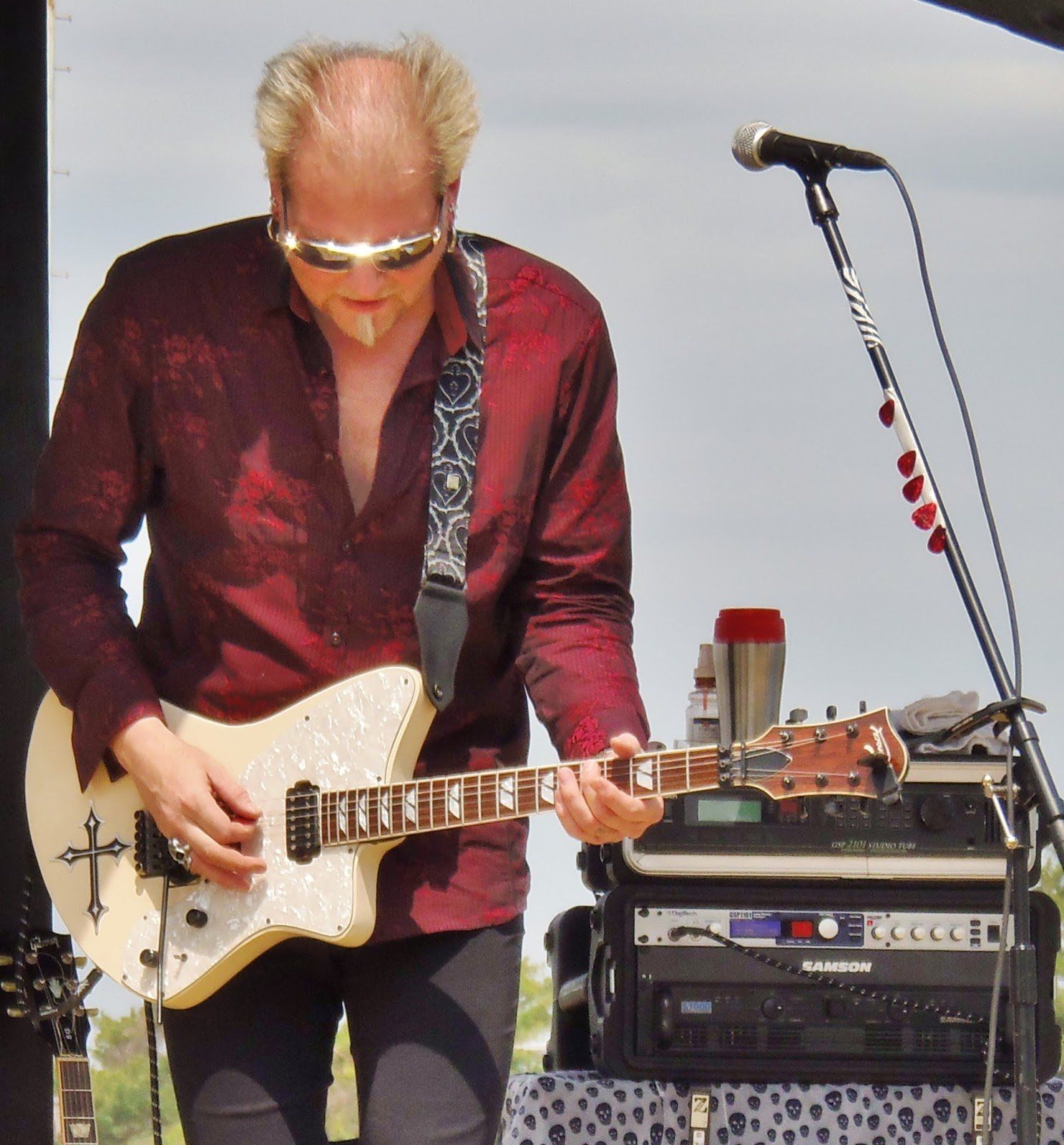 A man in a red shirt is playing a guitar