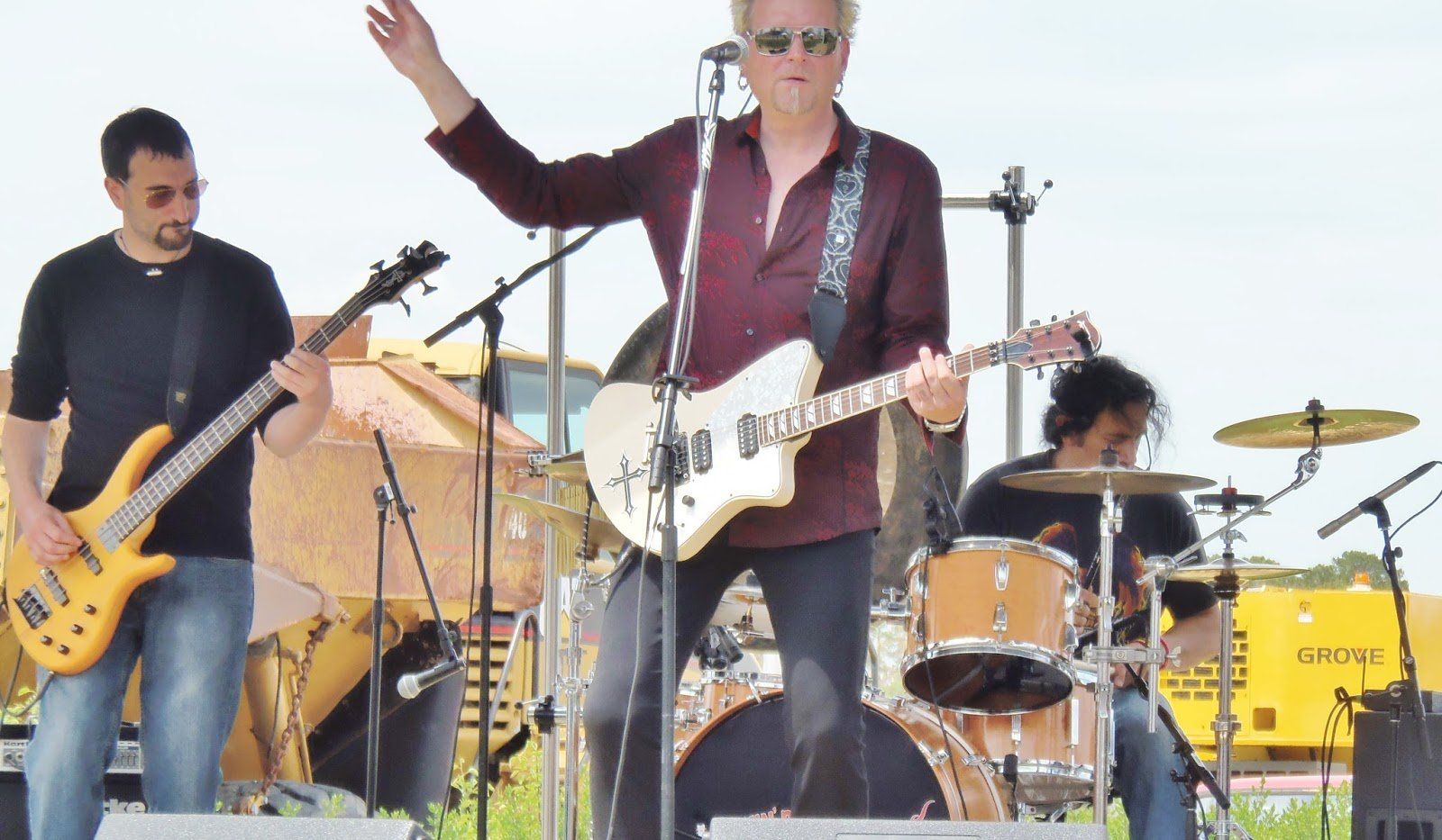 A man is playing a guitar and singing into a microphone on stage