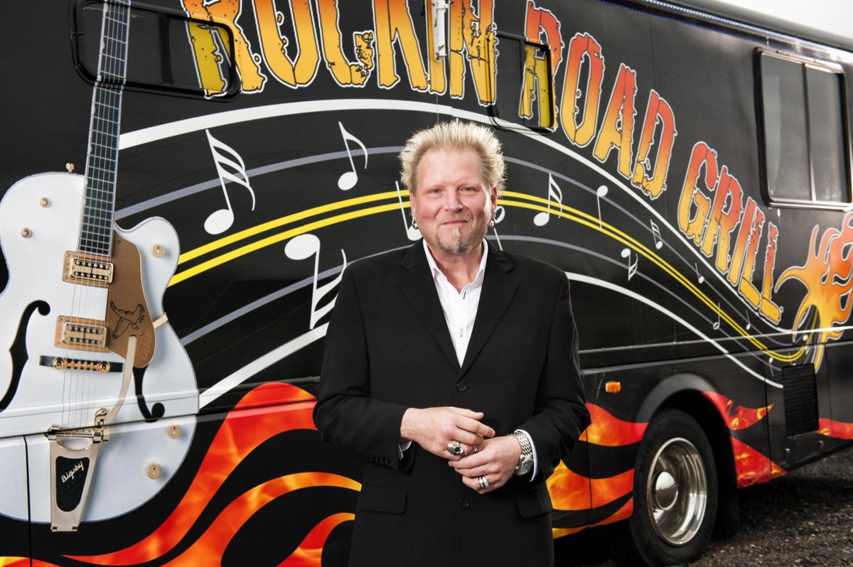 A man stands in front of a truck that says tulsa road grill