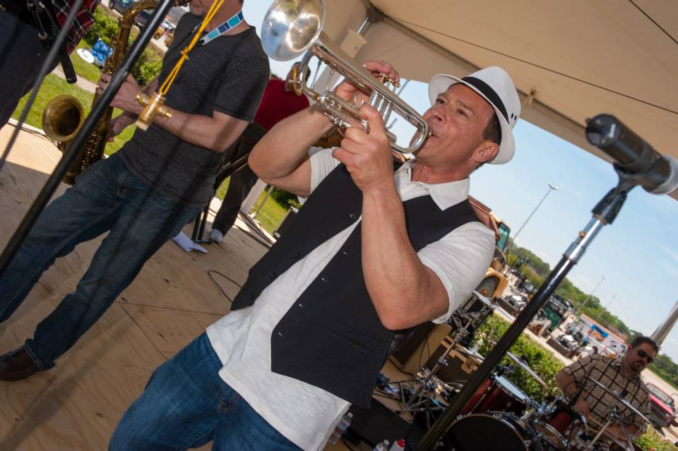 A man is playing a trumpet in a band.