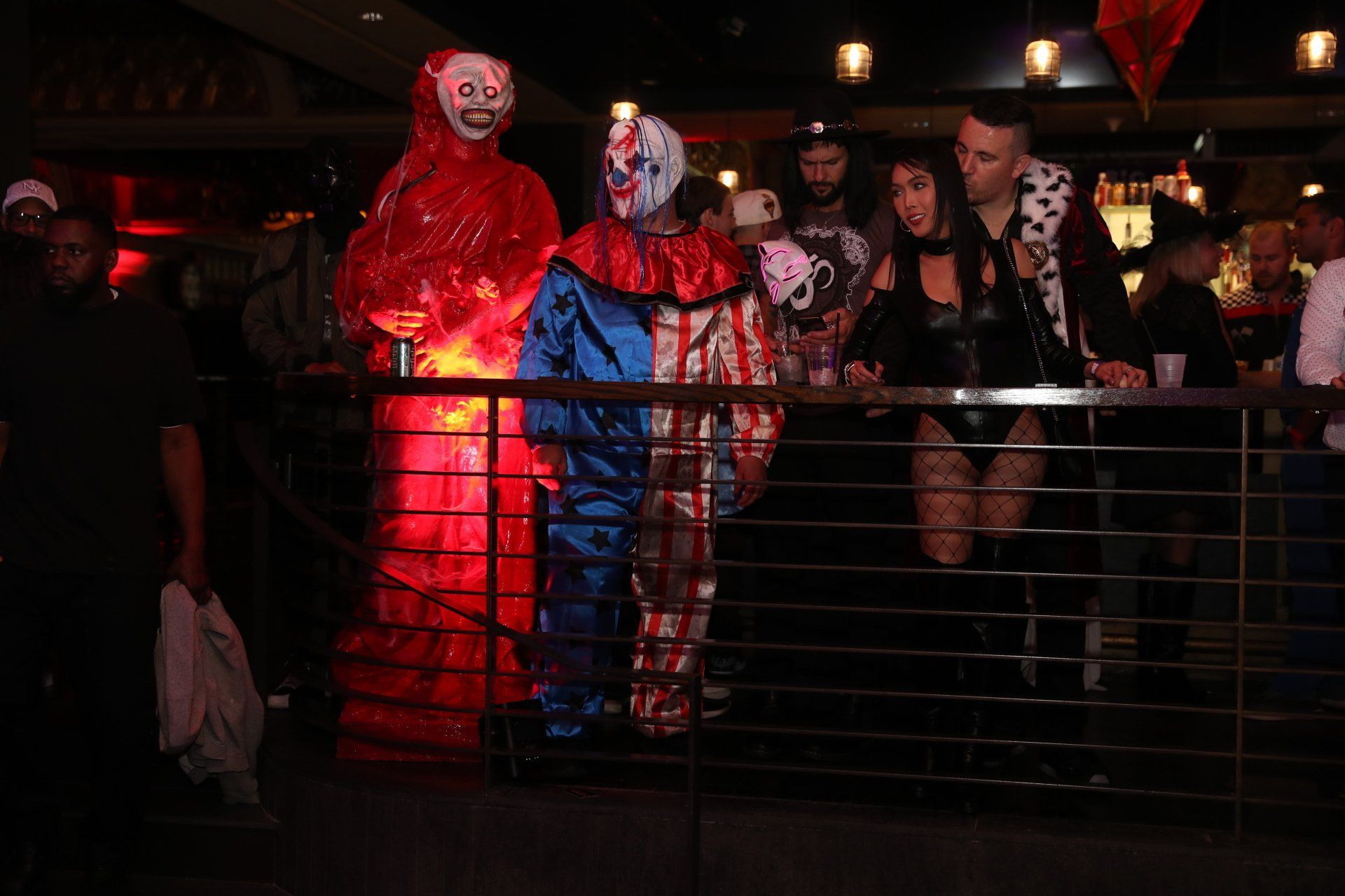 A group of people dressed in clown costumes are standing on a balcony.